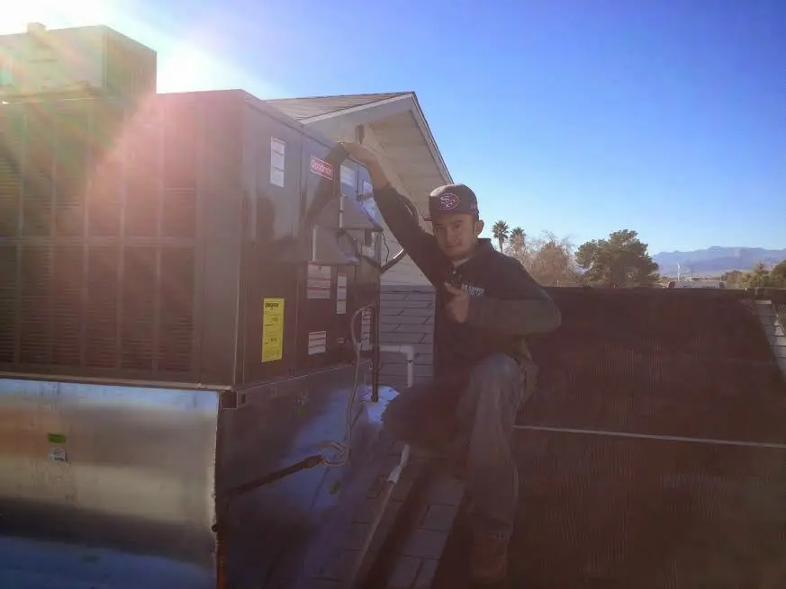 HVAC technician performing AC Tune-Up on a rooftop unit in Woodland